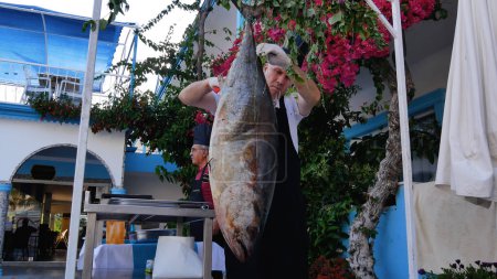 Photo for Side, Turkey - June, 20, 2023: A chef butchers a suspended large tuna fish in a Turkish hotel restaurant. Fresh fish, Mediterranean seafood in the diet - Royalty Free Image