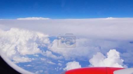 Photo for View from the airplane window: snow-white cumulus clouds and blue sky. The concept of travel, changes in life - Royalty Free Image
