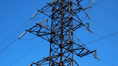 Foto de Un poste de línea de alta tensión con cables contra un cielo azul. Generación y transporte de electricidad. Seguridad energética - Imagen libre de derechos
