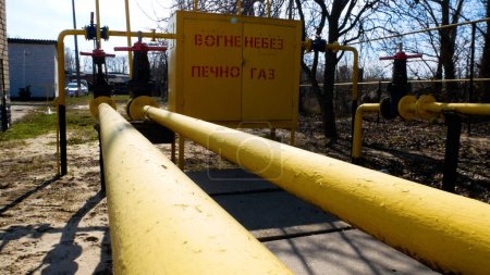 Foto de Tubo de gas amarillo con una válvula en la estación de distribución de gas. Producción de gas natural. Transporte de gas natural a los consumidores - Imagen libre de derechos