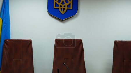 Téléchargez les photos : Chaises vides pour les juges dans une salle d'audience en Ukraine. La justice. En attendant la décision des juges dans la salle d'audience. Justice ukrainienne. - en image libre de droit