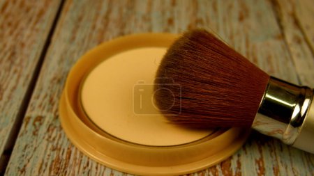Foto de El cepillo de maquillaje descansa sobre una caja abierta de polvo. Concepto de maquillaje femenino, cosméticos. - Imagen libre de derechos