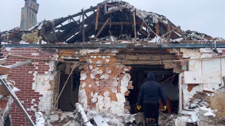 Téléchargez les photos : Kharkiv, Ukraine - 25 janvier 2024 : Un homme avec un chien se tient devant sa maison détruite après une frappe de missile par l'armée russe. bombardement de villages ukrainiens. Guerre russo-ukrainienne. - en image libre de droit