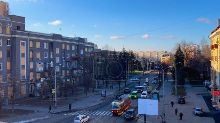 Foto de Kharkiv, Ucrania - 04 de diciembre de 2023: Paisaje urbano, vista superior. Hay tranvías y coches en la carretera. En los laterales hay viejos edificios de varios pisos. La vida de una ciudad moderna. - Imagen libre de derechos