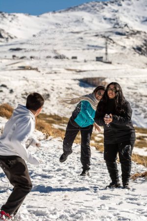 Téléchargez les photos : Latin people, famille dans les montagnes enneigées de sierra nevada à Grenade, jouer avec la neige par une journée ensoleillée, andalucia, espagne - en image libre de droit