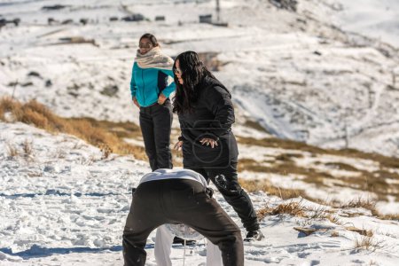 Téléchargez les photos : Trois jeunes latins jouant dans la neige dans les montagnes de sierra nevada - en image libre de droit