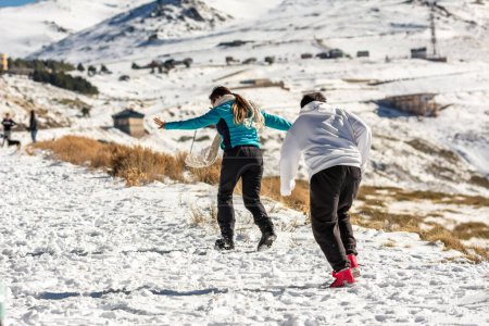 Téléchargez les photos : Des aventures glacées attendent Une famille latino se réjouit dans les collines enneigées de la Sierra Nevada, Grenade, se livrant à un plaisir givré - en image libre de droit