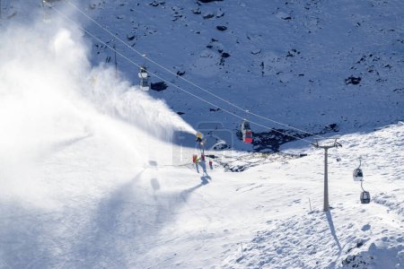Foto de Cañones de nieve, esparciendo nieve en las pistas junto a los teleféricos en la estación de esquí Sierra Nevada, - Imagen libre de derechos