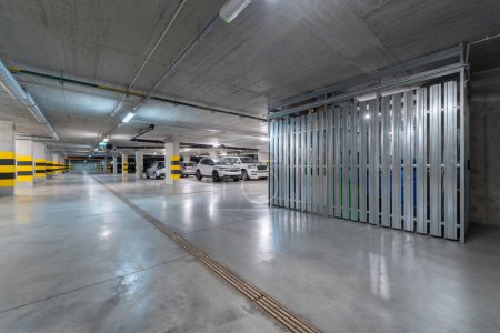 Un garage souterrain spacieux doté d'un éclairage lumineux, de places de stationnement clairement marquées et d'espaces de rangement sécurisés. La structure en béton moderne assure la sécurité et l'efficacité pour le stationnement des véhicules.