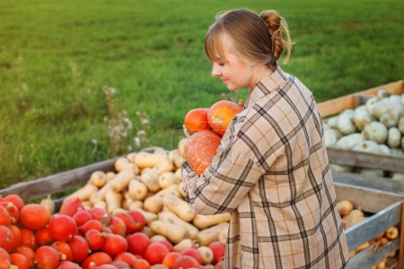 Téléchargez les photos : Portrait femme souriante choisissant la citrouille sur le patch de citrouille à la ferme pendant la saison d'automne - en image libre de droit