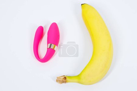 Vibrator und Banane auf weißem Hintergrund. Sexspielzeug. Erotisches Konzept