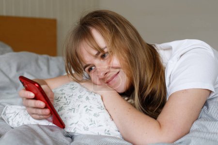 woman with phone in bed in the morning