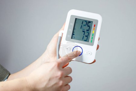 El hombre comprueba el monitor de presión arterial y el monitor de frecuencia cardíaca con manómetro digital. Salud y concepto médico
