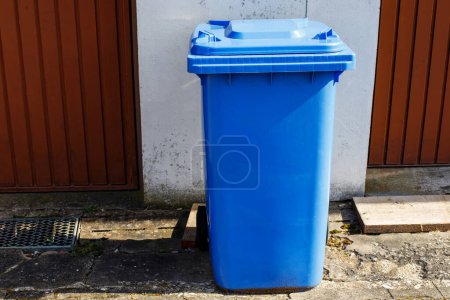 Behälter für Papier und Karton. Mülltrennung. Blauer Mülltrennung-Container im Hinterhof
