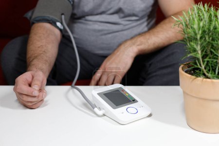 Téléchargez les photos : Homme en surpoids mesurant la pression artérielle close-up - en image libre de droit