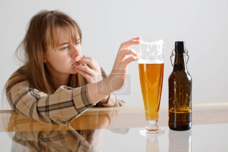 adicción al alcohol femenino. mujer toma un vaso de cerveza y se siente adicta