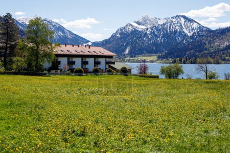 beautiful alpine landscape in bavaria. lakeside house with mountain views in the snow