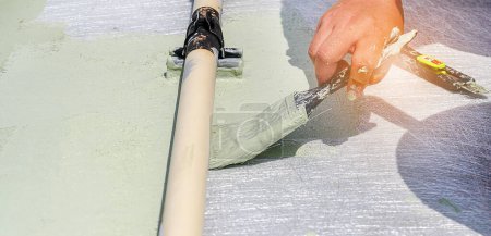 Foto de Pisos verdes pintados a mano con rodillos de pintura para impermeabilizar, red de refuerzo, suelo de cubierta de impermeabilización de reparación. - Imagen libre de derechos