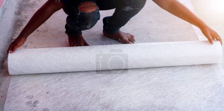 Téléchargez les photos : Maintien du travail de pose du tissu de maille pour rendre le système d'étanchéité du toit. - en image libre de droit