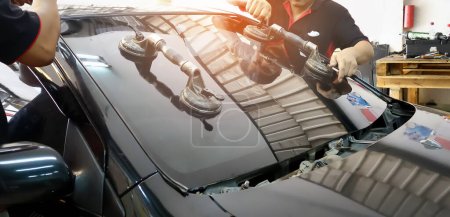 Automobil-Spezialkräfte ersetzen Windschutzscheibe oder Windschutzscheibe eines Autos in der Werkstatt einer Auto-Tankstelle