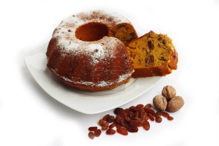 Téléchargez les photos : Gâteau de lapin de citrouille tranché maison avec raisins secs et noix isolé sur fond blanc - en image libre de droit