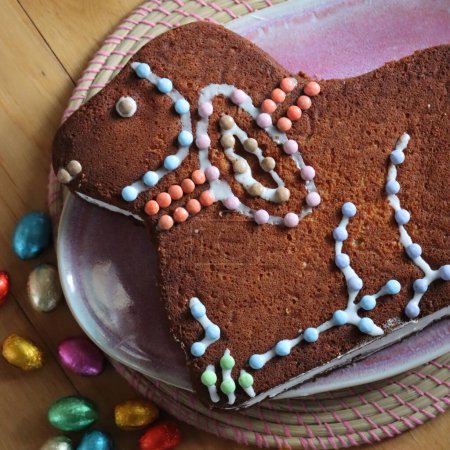 Photo for Traditional chcolate lamb cake decorated with chocolate and sugar for Easter on wooden table - Royalty Free Image