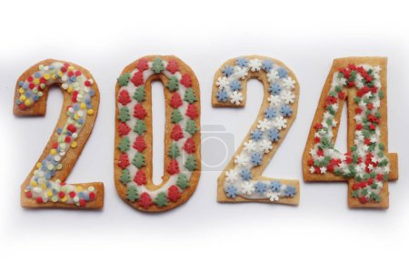 Foto de Galletas de corteza corta con decoración de esmalte de azúcar y salpicaduras en forma de números 2024 aislados sobre fondo blanco - Imagen libre de derechos