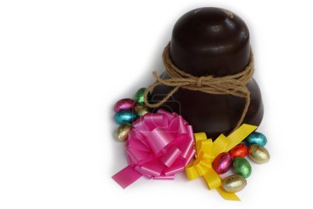 Easter chocolate bell with chocolate eggs and  pink and yellow bows isolated on white background