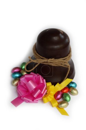 Cloche de chocolat de Pâques avec ?ufs en chocolat et noeuds roses et jaunes isolés sur fond blanc
