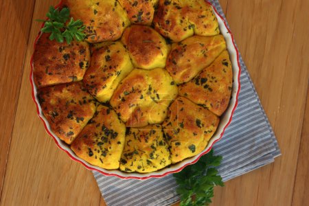 Turmeric curcuma and parsley bread . Healthy turmeric Bread in a cake pan on a gray striped napkin on wooden table