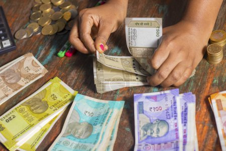 focus sélectif d'un banquier comptant les roupies en monnaie indienne.