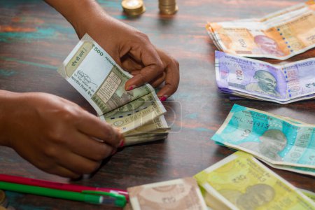 focus sélectif d'un banquier comptant les roupies en monnaie indienne.