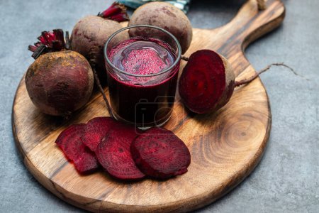 selective focus of a beet root glass juice with lot of fresh beet roots.