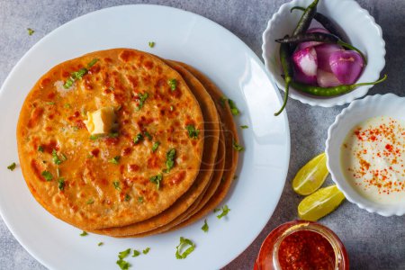 North Indian famous food Aloo Paratha with mango pickle and butter.