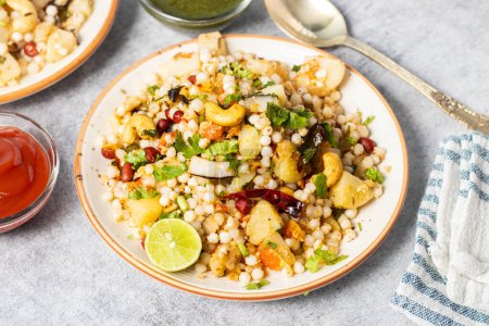 Photo for Sabudana Khichdi is a gluten-free Indian dish made with soaked tapioca pearls, potatoes, peanuts, and spices. Its popular during fasting days. - Royalty Free Image