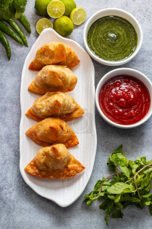 Photo for Selective focus Samosa, Spiced potato-filled pastry, crispy, Savory, popular Indian snack with tomato and mint chutney. - Royalty Free Image