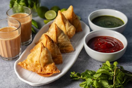 selective focus Samosa, Spiced potato-filled pastry, crispy, Savory, popular Indian snack with tomato and mint chutney. 