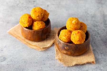 Indian Sweets laddoo or Laddu made of gram flour on a grey background. 