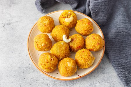 Indian Sweets laddoo or Laddu made of gram flour on a grey background. 