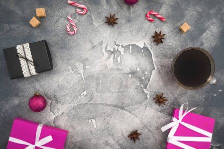 Photo for Christmas frame composition with coffee cup, candy and gift boxes on dark background. Flat lay, top view - Royalty Free Image