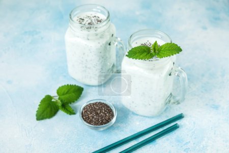 Foto de Sabroso yogur o batido con semillas de chía y pajitas de vidrio, comida vegetariana - Imagen libre de derechos