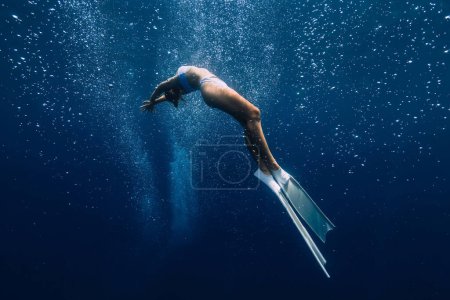 Foto de Mujer liberadora posando bajo el agua con burbujas de aire. Freediving con hermosa chica en el océano - Imagen libre de derechos
