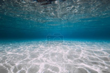Foto de Océano azul con arena blanca y luz solar bajo el agua. Fondo oceánico transparente - Imagen libre de derechos