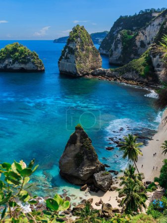Téléchargez les photos : Plage de diamants avec océan bleu et littoral pittoresque avec rochers et montagne à Nusa Penida - en image libre de droit