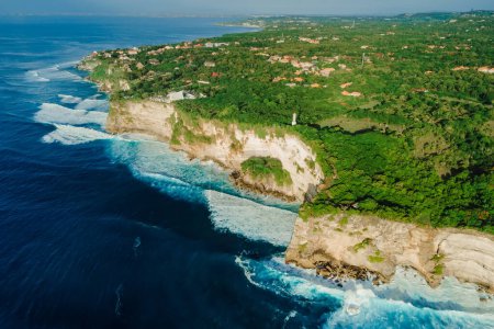 Foto de Vista aérea de la costa escénica con acantilados, océano con olas y faro en Uluwatu, Bali - Imagen libre de derechos