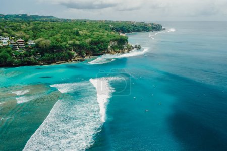 Foto de Blue ocean with waves and coastline on Padang Padang surf spot in Bali. Aerial view - Imagen libre de derechos