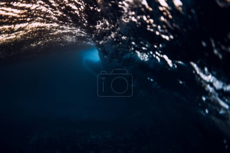 Téléchargez les photos : Barrel wave crash in ocean with warm sunset or sunrise tones. Underwater background with surfing wave - en image libre de droit