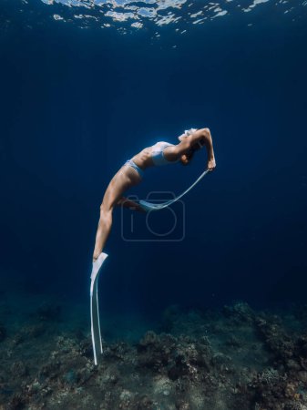 Téléchargez les photos : Professional freediver fun and posing underwater in blue ocean - en image libre de droit