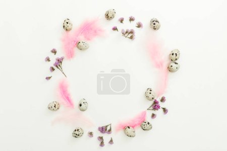 Foto de Round composition with easter eggs, flowers and pink feathers on white background. Flat lay, top view - Imagen libre de derechos