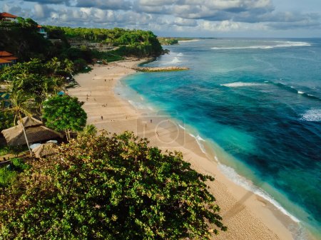 Tropical beach with turquoise ocean and waves in Bali island. Aerial view